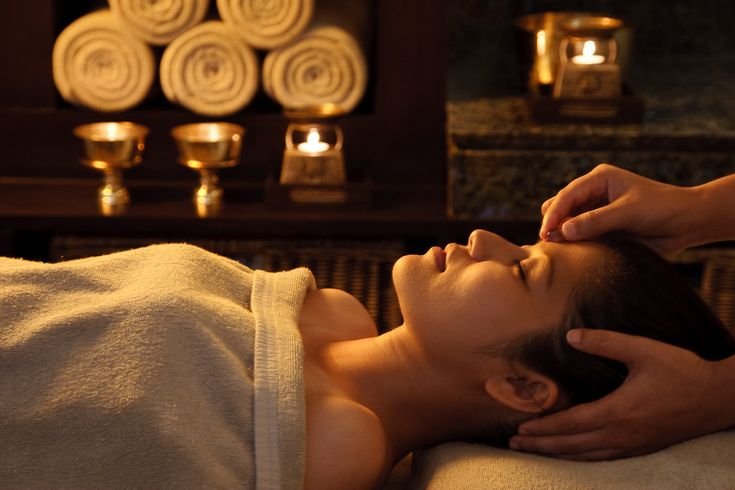 Relaxing spa treatment with a soothing head massage and cozy candlelit ambiance.