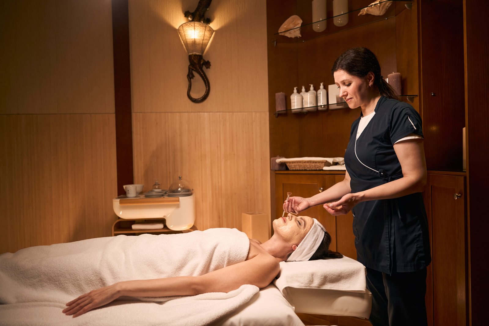 A focused cosmetologist performing a beauty treatment on a woman's face, enhancing her skin's health and appearance